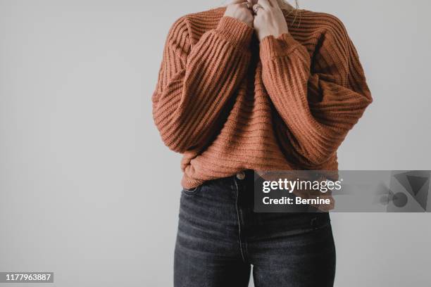 woman wearing cozy sweater and jeans - women's winter clothes stockfoto's en -beelden