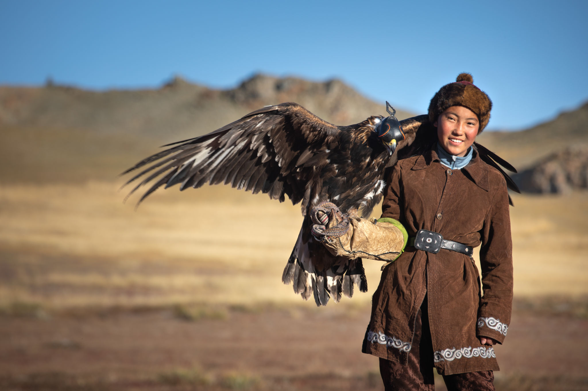 Young kazakh eagle hunter with his golden eagle. Young kazakh eagle hunter with his golden eagle.