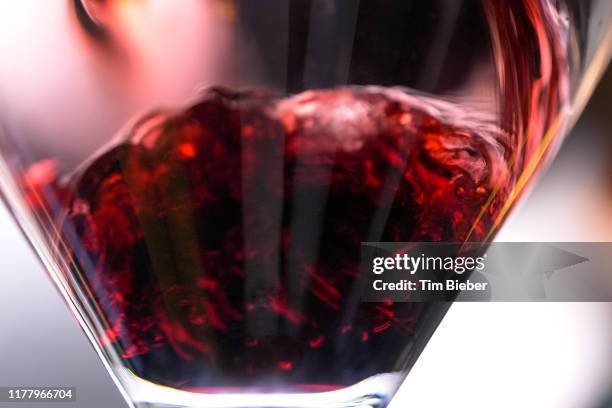 red wine being poured in to a wine glass. - maroon swirl stock pictures, royalty-free photos & images