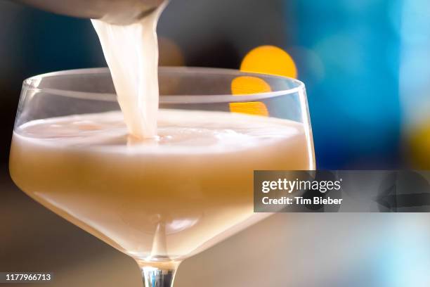 prohibition gin fizz craft cocktail being poured into glass - craft cocktail stock pictures, royalty-free photos & images