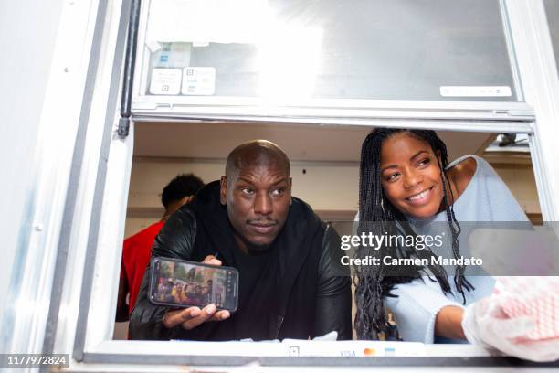 Tyrese Gibson and Naomie Harris are seen serving from a food truck during the "Black & Blue" cast members' visit to Morehouse College on October 24,...