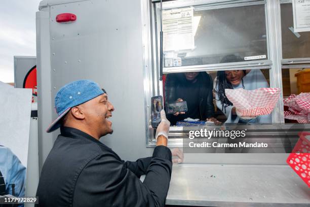 Deon Taylor, Tyrese Gibson, and Naomie Harris are seen serving from a food truck during the "Black & Blue" cast members' visit to Morehouse College...