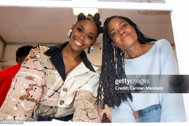 Nafessa Williams and Naomie Harris are seen serving from a food truck during the "Black & Blue" cast members' visit to Morehouse College on October...