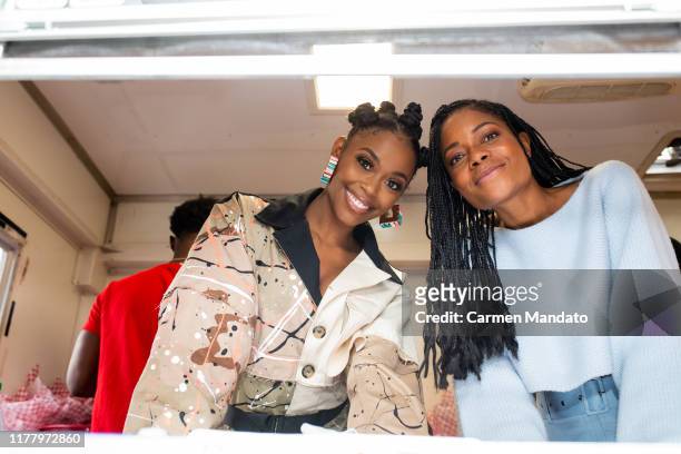 Nafessa Williams and Naomie Harris are seen serving from a food truck during the "Black & Blue" cast members' visit to Morehouse College on October...