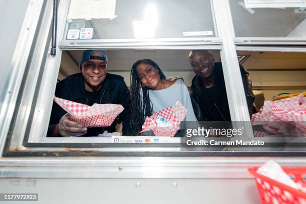Deon Taylor, Tyrese Gibson, and Naomie Harris are seen serving from a food truck during the "Black & Blue" cast members' visit to Morehouse College...