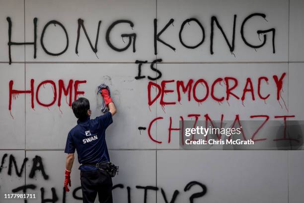 Man cleans graffiti from the front of a building after the weekends pro-democracy protests on September 30, 2019 in Hong Kong, China. Pro-democracy...