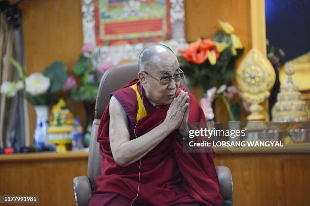 Tibetan spiritual leader the Dalai Lama gestures as he interacts with media members during an event in McLeod Ganj on October 25, 2019.