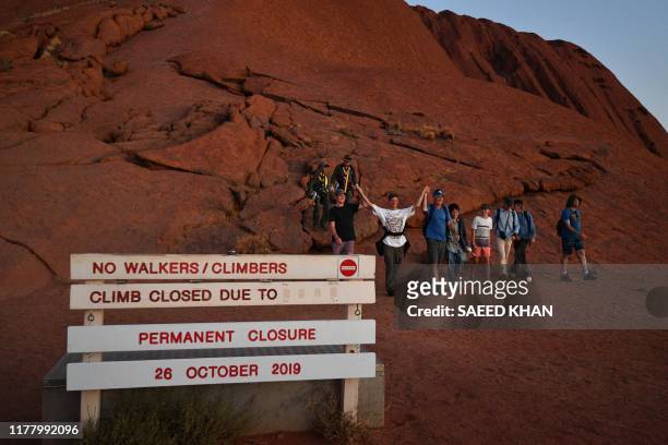 The final batch of tourists to climb Uluru, also known as Ayers Rock, return at day's end marking the start of a permanent ban on climbing the...
