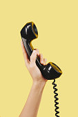 Hand with black telephone receiver