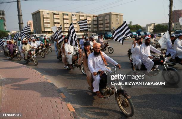 Activists of Jamiat Ulema-e Islam carry party flags as they march in a rally in Karachi on October 25, 2019. - JUI chief Maulana Fazal-ur-Rehman had...