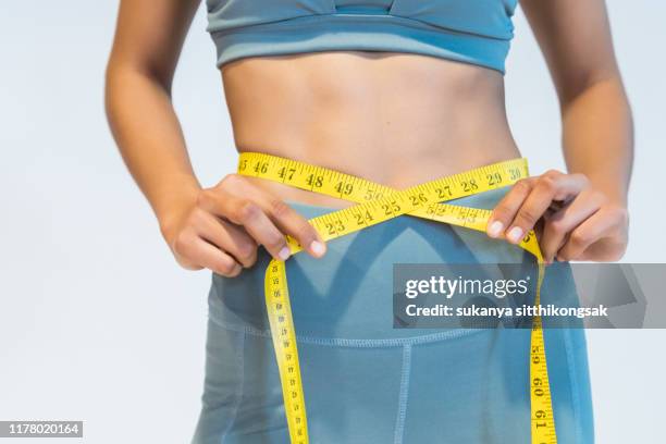 diet and fitness concept.slim woman measuring waist. - poids photos et images de collection