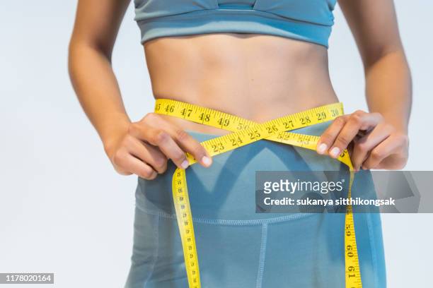 diet and fitness concept.slim woman measuring waist. - waist stockfoto's en -beelden
