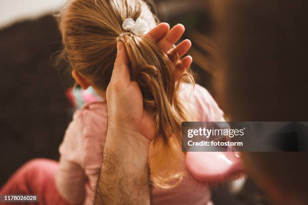 padre che si spazzola i capelli della figlia piccola. - pettine foto e immagini stock