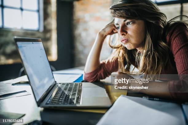 bored woman reading an e-mail over computer. - bores stock pictures, royalty-free photos & images