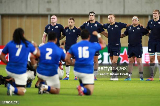 The Scotland players look on as the Samoa players perform the Siva Tau prior to the Rugby World Cup 2019 Group A game between Scotland and Samoa at...