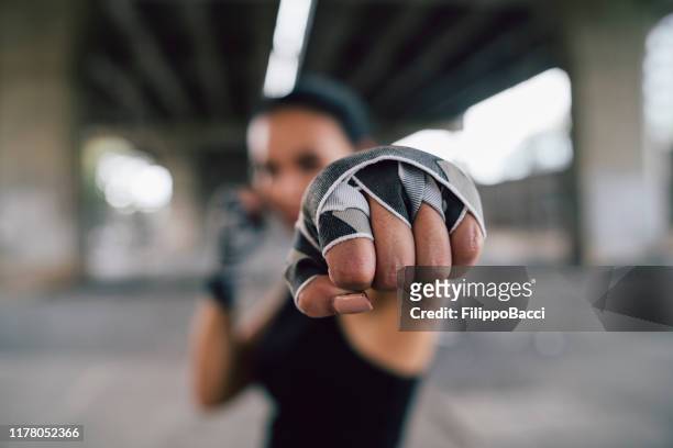 poderosa joven golpeando - combat sport fotografías e imágenes de stock