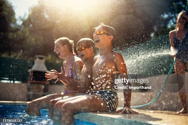 mother splashing kids with garden hose - teen disbelief stock pictures, royalty-free photos & images