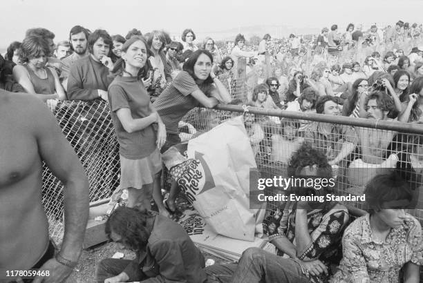 American singer, songwriter and musician Joan Baez joins rock fans in the audience to watch a band perform on stage at the Isle of Wight Festival...