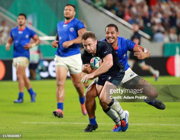 Greig Laidlaw of Scotland breaks through Ed Fidow of Samoa to go on and score his team's second try during the Rugby World Cup 2019 Group A game...