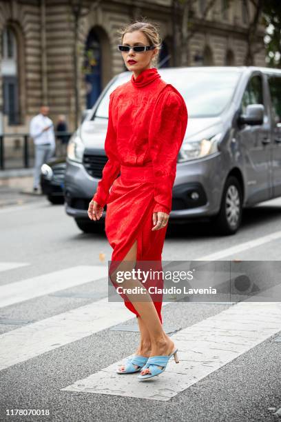 Elizabeth Sulcer, wearing a red midi dress and light blue sandals, is seen outside the Redemption show during Paris Fashion Week - Womenswear Spring...