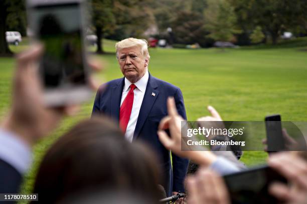 President Donald Trump pauses while speaking to members of the media before boarding Marine One on the South Lawn of the White House in Washington,...