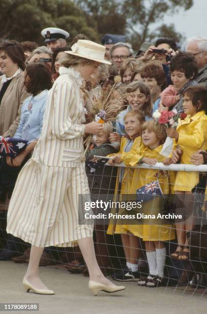 Diana, Princess of Wales wearing a suit by Arabella Pollen and a John Boyd hat in Adelaide, Australia, 5th April 1983. Onlookers are holding the flag...