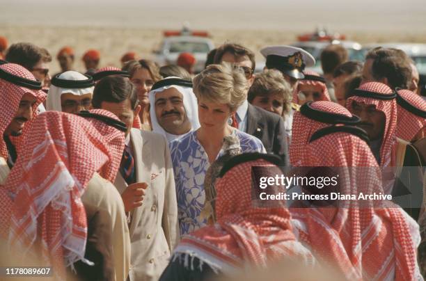 Princes Charles and Diana, Princess of Wales attend a picnic in the desert near Riyadh, Saudi Arabia, November 1986. She is wearing a blue and white...