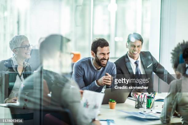 vrolijke zakenman praat met zijn collega's op kantoor. - business meeting stockfoto's en -beelden