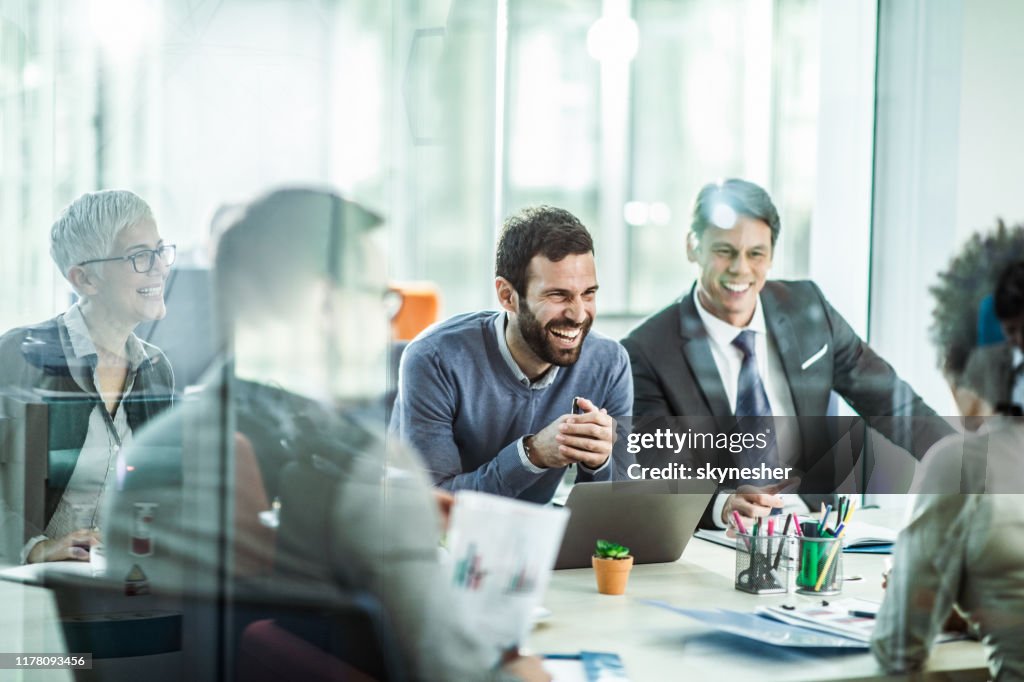 Cheerful businessman talking to his colleagues in the office.