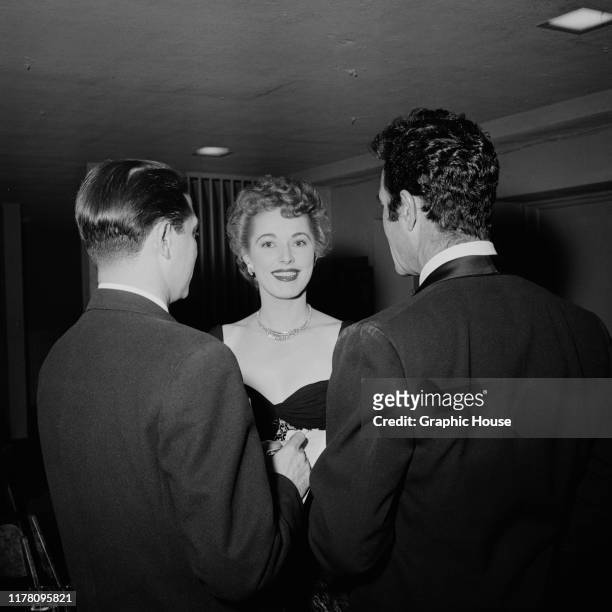 American actress Eleanor Parker with two men, circa 1955.
