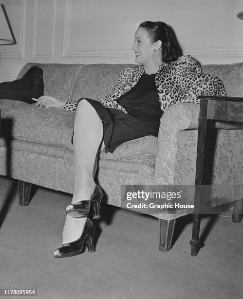 American actress Dorothy Lamour smoking a cigarette in a leopard print jacket, circa 1945.