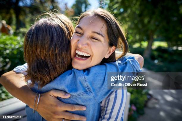 happy senior woman and her adult daughter hugging in a park - gratitude foto e immagini stock