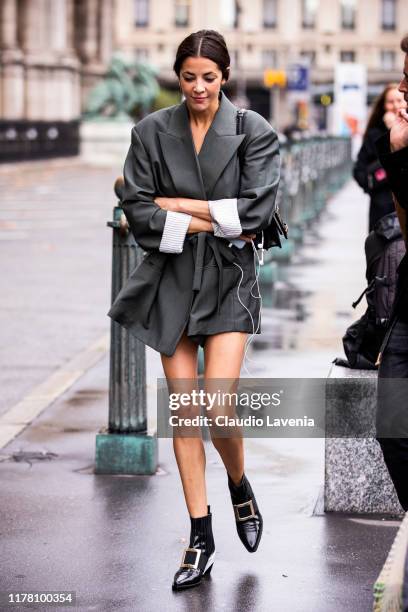 Guest, wearing a grey blazer, black bag and black boots, is seen outside the Redemption show during Paris Fashion Week - Womenswear Spring Summer...