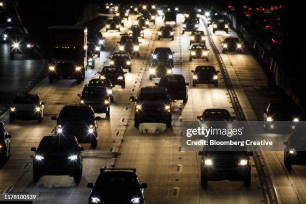 heavy vehicle traffic on the freeway at night - tour bus stock pictures, royalty-free photos & images