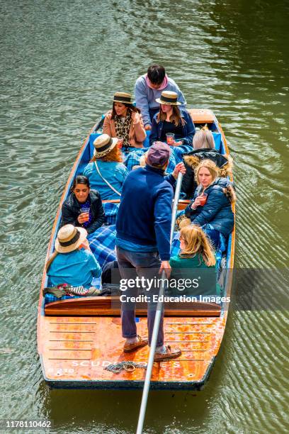 Tourists in straw hats punting on the river Cam, Cambridge University, England. UK.