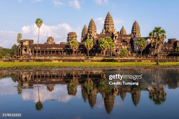 popular view for tourist attraction ancient temple complex angkor wat with reflected in lake siem reap, cambodia - angkor wat bayon stockfoto's en -beelden