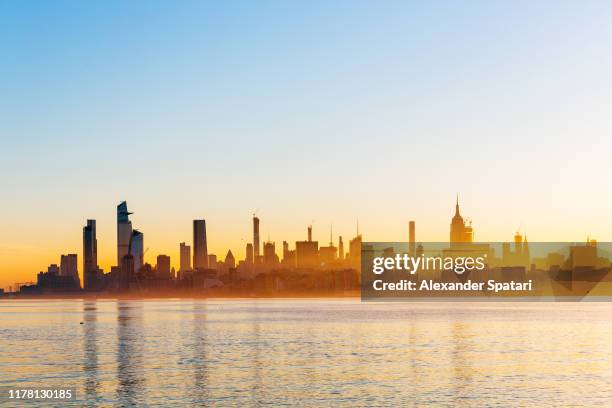 new york city manhattan skyline at sunrise with hudson river, united states - sunrise new york stock-fotos und bilder