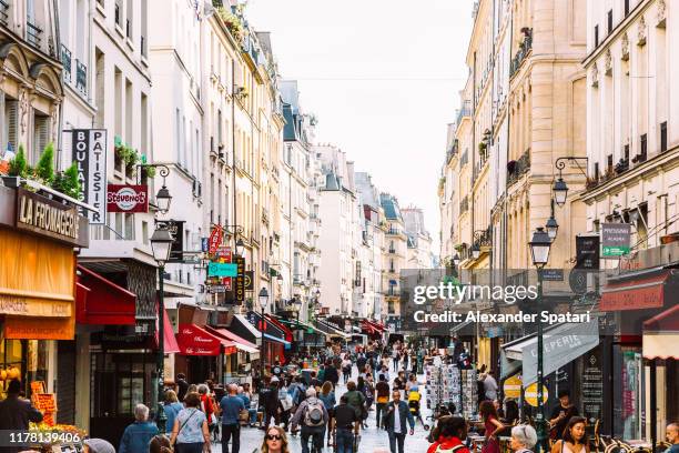 crowds of people at rue montorgueil pedestrian street in paris, france - paris restaurant stock pictures, royalty-free photos & images