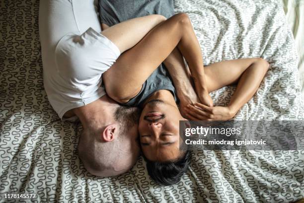 abrazo temprano por la mañana - pareja abrazados cama fotografías e imágenes de stock