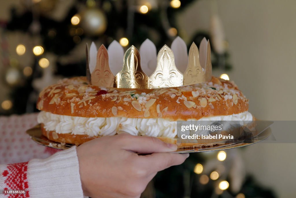 Woman holding Epiphany cake with King Gift