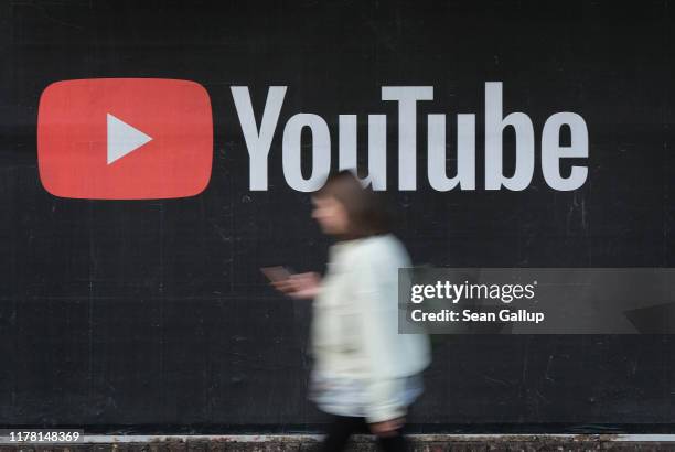 Young woman with a smartphone walks past a billboard advertisement for YouTube on September 27, 2019 in Berlin, Germany. YouTube has evolved as the...