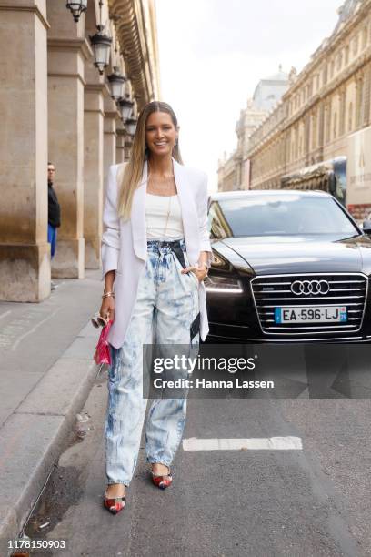 Helena Bordon wearing white blazer and tie dye denim jeans outside Giambattista Valli during Paris Fashion Week Womenswear Spring Summer 2020 on...