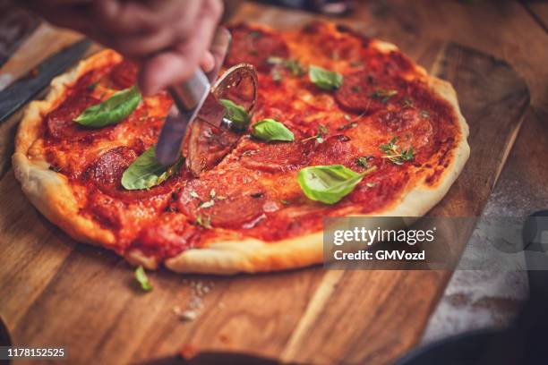 zubereitung von pizza in einer kochpfanne mit tomatensauce und salami - italienisches essen stock-fotos und bilder