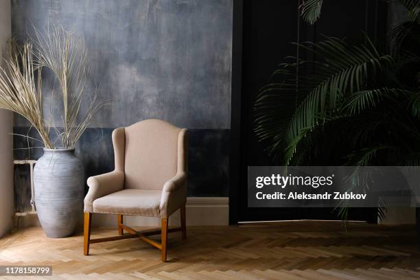 beige chair and a large vase near the window in the hall, next to a palm tree near the door. - entrance hall photos et images de collection