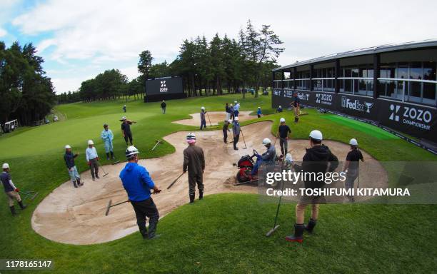 Workers repair a bunker at the 18th hole damaged by the previous day's heavy rain prior to the second round of the PGA ZOZO Championship golf...