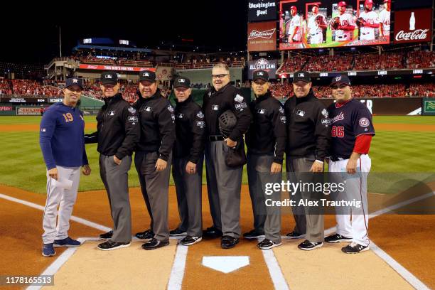 Bench Coach Joe Espada of the Houston Astros and Ali Modami of the Washington Nationals pose for a photo with the umpiring crewat home plate prior to...