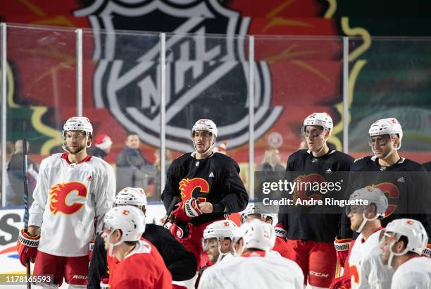 Michael Frolik, Travis Hamonic, Michael Stone and Mark Giordano of the Calgary Flames look on during practice in advance of the 2019 Tim Hortons NHL...