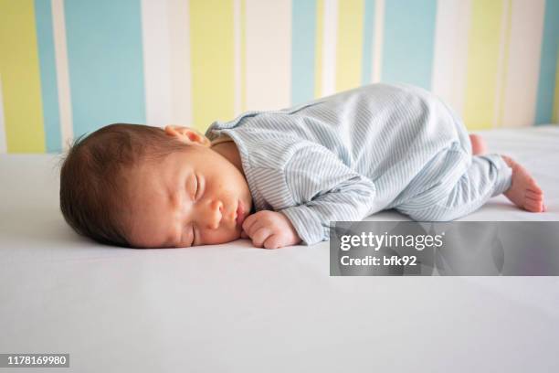neugeborenes baby boy am bett schlafen. - week one stock-fotos und bilder