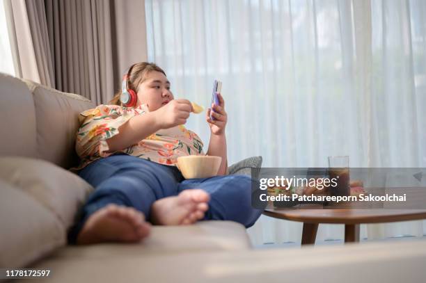 fat woman eating unhealthy food - fat asian woman stock-fotos und bilder