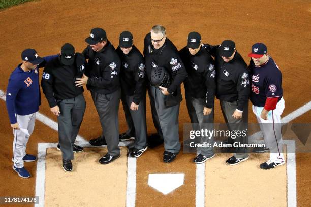 Bench Coach Joe Espada of the Houston Astros and Ali Modami of the Washington Nationals pose for a photo with the umpiring crew at home plate prior...